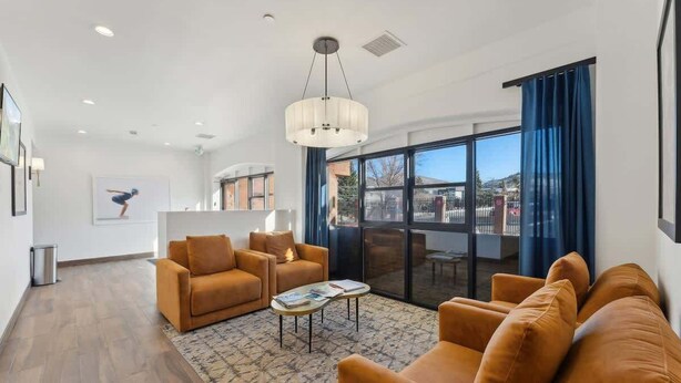 A modern living room with a sofa set, a coffee table, and a large window with curtains. - Ski-In Out Mountain Luxury Studio Sleeps 6 (Park City)