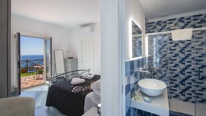 Ein modernes Schlafzimmer mit einem Bett, einem Nachttisch und Blick ins Freie.