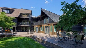 A modern building with a wooden facade, a balcony, and outdoor seating. - Twin Pine Manor Bed & Breakfast (Ephrata)