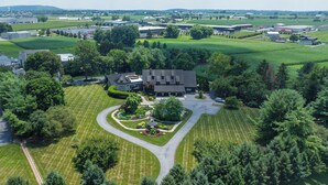 An aerial view of a large estate with a central building surrounded by manicured lawns and trees. - Twin Pine Manor Bed & Breakfast (Ephrata)