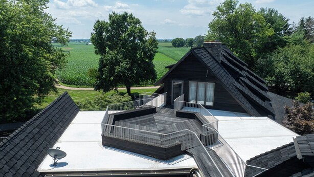 A modern house with a sloped roof, a wooden deck, and a satellite dish. - Twin Pine Manor Bed & Breakfast (Ephrata)
