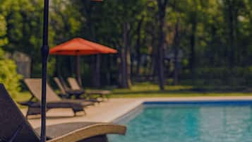 Una piscina al aire libre de temporada, sombrillas
