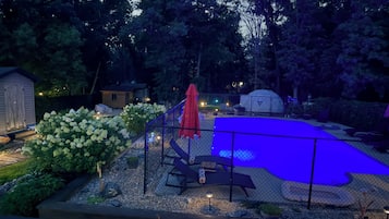 Una piscina al aire libre de temporada, sombrillas