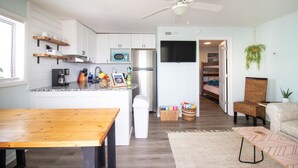 A modern kitchen with white cabinets, a microwave, a refrigerator, and a ceiling fan. - #5 Steps away from beach! 1 mile from CB Boardwalk (Carolina Beach)
