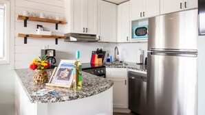 A modern kitchen with white cabinets, a stainless steel refrigerator, a microwave, and a granite countertop. - #5 Steps away from beach! 1 mile from CB Boardwalk (Carolina Beach)