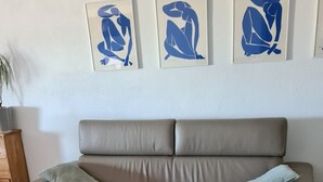 En stue med en brun lædersofa, to puder med mønster og et træbord.
