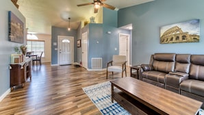 A spacious living room with a brown leather sofa, wooden coffee table, and a blue patterned rug. - Modern 3BR w/ Mountain Views • Sleeps 8 • 2 car garage plus extra parking (Hamilton)