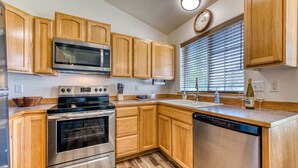 A kitchen with wooden cabinets, stainless steel appliances, a microwave, oven, and dishwasher. - Modern 3BR w/ Mountain Views • Sleeps 8 • 2 car garage plus extra parking (Hamilton)