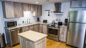 A modern kitchen with wooden cabinets, a stainless steel refrigerator, and a built-in oven.