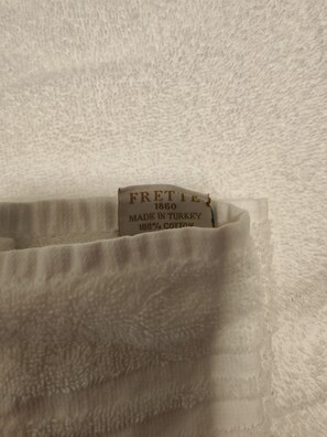 A tag with the text "FRETTE 1860 MADE IN TURKEY 100% COTTON".