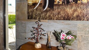 A wooden table with a vase of flowers and a decorative item. - Luxurious Two Bedroom Double Storey Apartments (Lusaka)