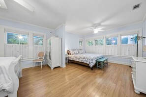 A bedroom with a bed, a chair, a dresser, and a window with shutters. - 3 Houses 30 guests Country 14 acre Pecan Orchard (Maxwell)