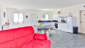 A modern kitchen with white cabinets, a black oven, and a white refrigerator. - Le Gois - Jardin -  Marais salants (Beauvoir-sur-Mer)