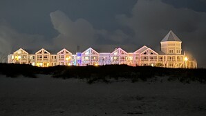 Un hotel amb vistes a la platja i diversos edificis, incloent una torre destacada.