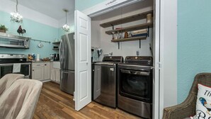 A compact kitchen with stainless steel appliances, a microwave, and a refrigerator. - RoosterHouse Countryside Pecan Farm 6ac SanMarcos (Maxwell)