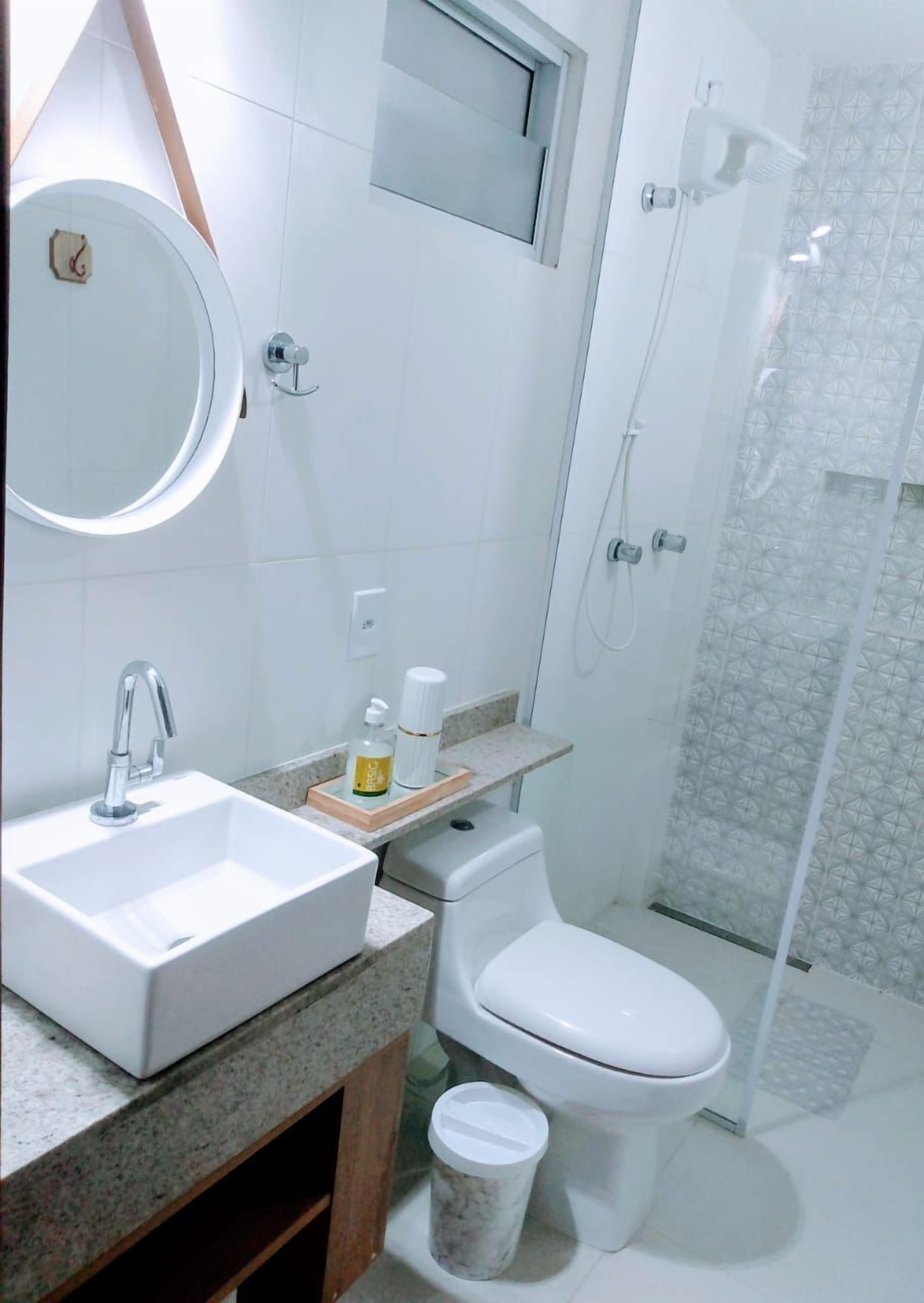 A modern bathroom with a sink, toilet, and shower.
