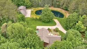 Ein Haus, umgeben von dichten Bäumen und einem kleinen Teich.