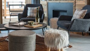 Ein modernes Wohnzimmer mit Kamin, Ledersofa und Fernseher.