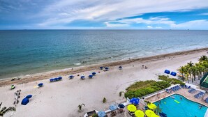 A beach with umbrellas, a swimming pool, and a view of the ocean. - Oceanfront Luxury 2/2 Condo w/ Amazing Views! (Fort Lauderdale)