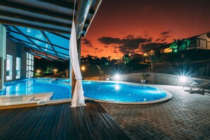 Alberca al aire libre, sombrillas en la alberca y camastros 