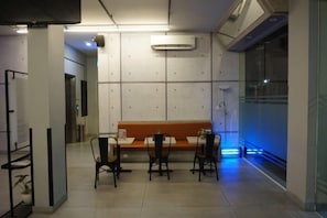 A dining area with a bench, chairs, and a table. - Sambina Prime (West Jakarta)