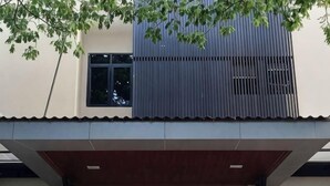 A modern building with a flat roof, a large window, and a covered entrance area. - Sambina Prime (West Jakarta)