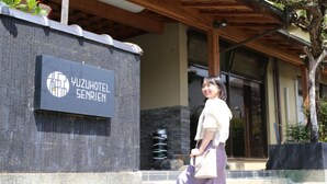 A sign for Yuzu Hotel Senrien with a modern architectural style.