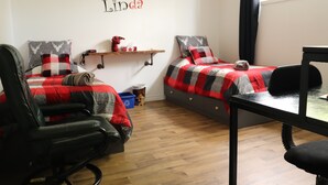 Un dormitorio con dos camas, un escritorio y una silla.