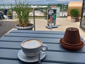 A table with a cup of coffee and a terracotta pot. - Ferienhaus Mühlenblick 41 Nr. 2 (Wittmund)
