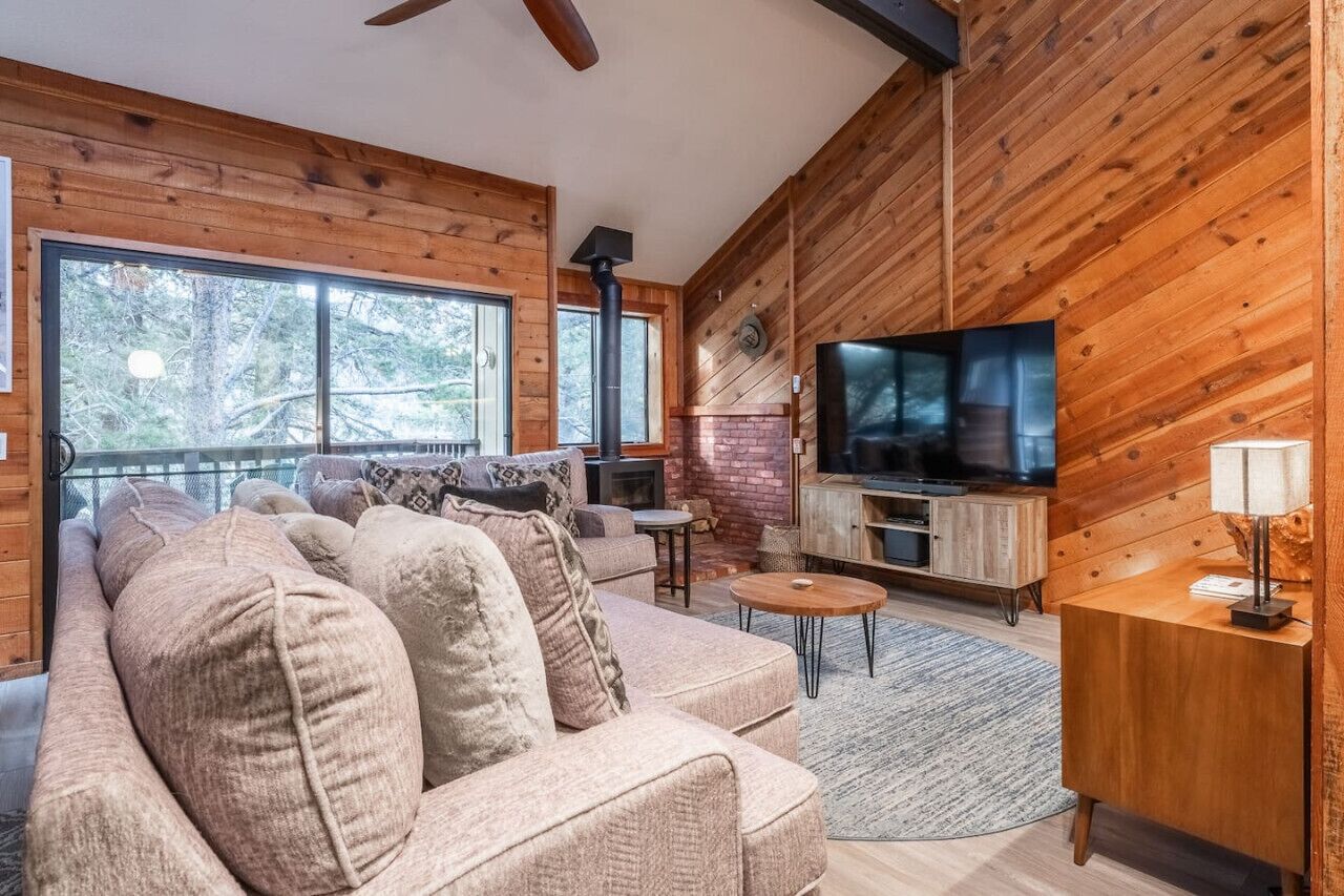 Ein gemütliches Wohnzimmer mit einer großen Couch, einem Fernseher und einem Kamin.
