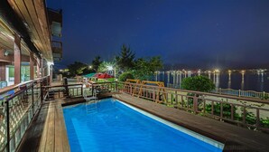 Una piscina con muelle de madera y vista al agua.
