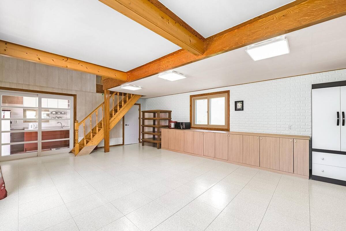 Una cocina amplia con vigas de madera, una escalera y un armario grande.