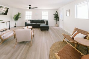Relax in this stylish living room with a large sofa, coffee table, and two comfortable chairs.