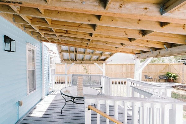 Enjoy a peaceful outdoor space with a covered deck, perfect for relaxing with a table and seating area.