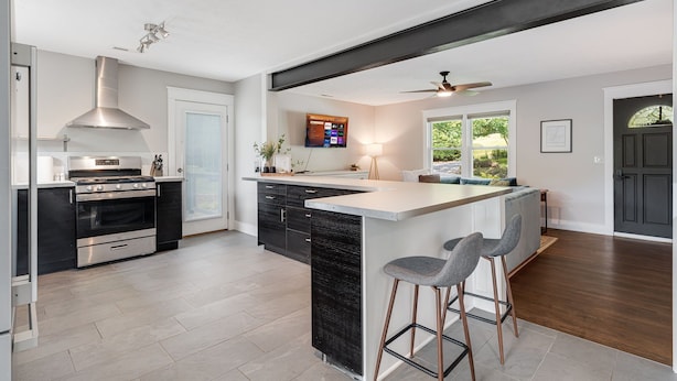 Una cocina moderna con una isla central, electrodomésticos de acero inoxidable y un ventilador de techo.