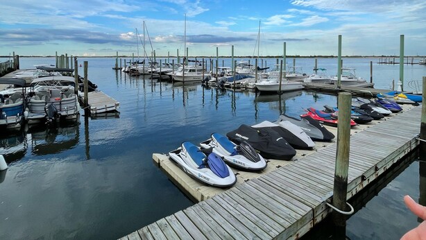 A marina with boats docked at wooden piers, calm water, and a clear sky. - Charming spacious 1933 newly renovated private home. Walk to trails (Highlands)