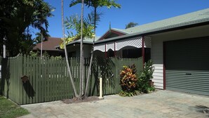 A residential property with a fenced backyard, a garage, and a small porch with a lattice roof. - Arcadia Gardens (Arcadia)