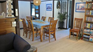 Un coin repas avec une table et des chaises, une bibliothèque et une plante en pot.