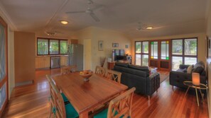 A spacious living area with a wooden dining table, sofas, and a television. - Lemonade (Arcadia)