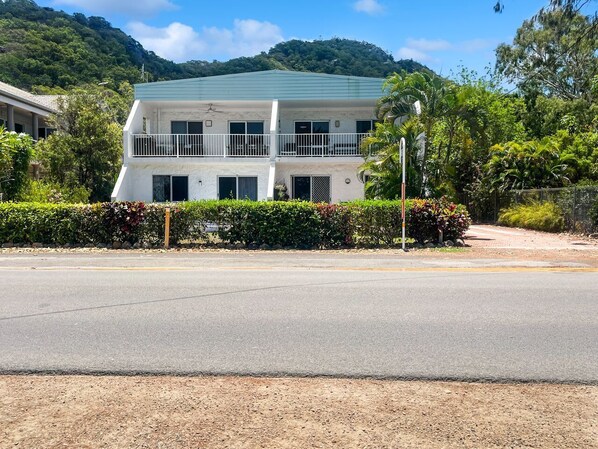 A two-story building with a green roof, a balcony on the upper floor, and a well-maintained garden in front. - Arcadia Beach Unit 4 (Arcadia)