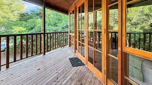 A wooden deck with a railing, large windows, and a view of greenery. - Kameruka (Arcadia)