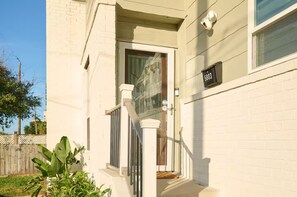 A white building with a black mailbox labeled '5803' and a door.