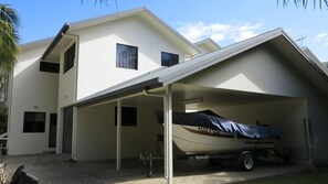 A two-story house with a covered garage and a boat on a trailer.
