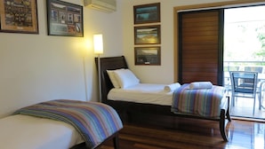 A room with two beds, a desk, a chair, and a balcony with a table. - Sol Y Olas Sun & Waves (Arcadia)