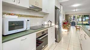 A modern kitchen with white cabinets, a microwave, a toaster, and a refrigerator.