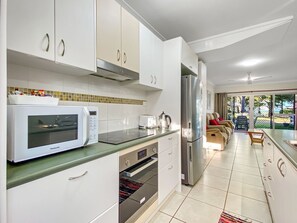 Eine moderne Küche mit weißen Schränken, einer Mikrowelle, einem Toaster und einem Kühlschrank.