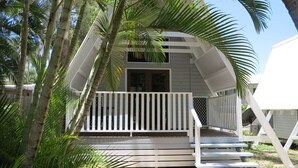 A two-story house with a white exterior, a wooden deck, and a white railing. - Picnic Bay Chalet Unit 2 (Picnic Bay)