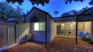 A covered outdoor area with a barbecue grill, a seating area with chairs, and a fenced patio. - Loyang Apartment 2 (Arcadia)