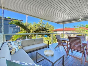 A covered outdoor seating area with a sofa, chairs, and a table. - Magnetic Haven Unit 5 (Arcadia)