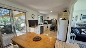 A compact kitchen with a dining area, a built-in oven, and a refrigerator.